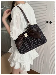 Close-up of polka dot tote bag featuring a large brown bow and delicate lace trim detail