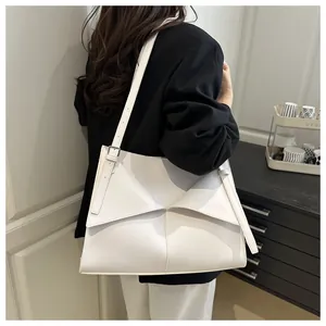 Détail d'un cabas en cuir blanc avec pli origami géométrique et boucle en argent poli