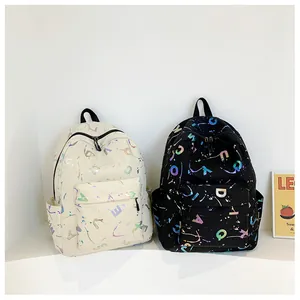 Detail of canvas backpacks showing colorful letter prints and ink splash textures