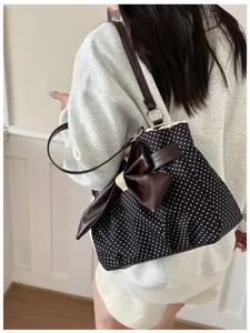 Close-up of polka dot tote bag featuring a large leather bow and lace edge detailing