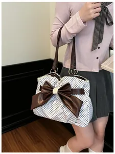 Detail of polka dot tote bag with leather bow, lace trim, and sturdy shoulder straps