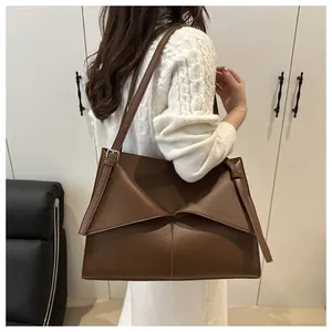Vue détaillée du sac cabas marron foncé sur modèle montrant le rabat et la bandoulière
