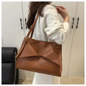 Détail du sac cabas en cuir marron caramel avec design géométrique et bandoulière réglable