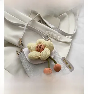 Close-up of fabric floral phone bag with 3D yellow flower and green drawstring tassel