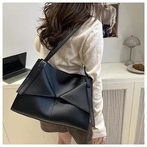 Détail d'un grand sac cabas noir avec une structure en cuir plié géométrique