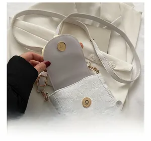 Detail shot of the white floral textured bag showing golden magnetic closure and interior