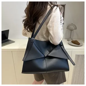 Détail du sac cabas noir minimaliste montrant le rabat géométrique superposé unique