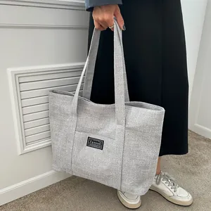 Detailed macro view of the grey woven texture and fashion label on this tote bag