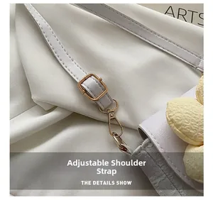 Close-up of adjustable leather shoulder strap with gold metal buckle and floral detail