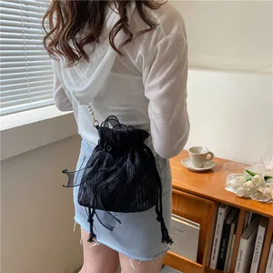 Elegant black bucket bag with pearl strap, mesh bow detail and drawstring closure
