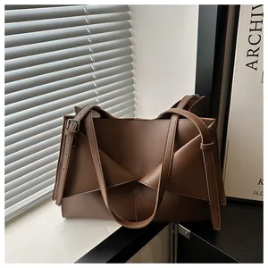 Détail du sac cabas pliant géométrique marron foncé avec texture cuir mat premium