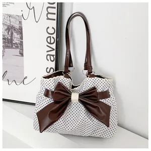 Detailed view of canvas tote bag featuring polka dots, large bow and lace trim edging