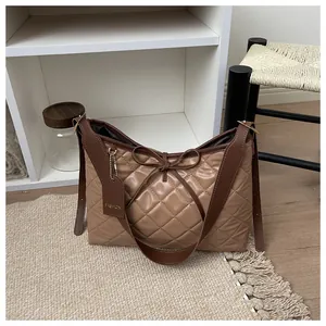 Detail of brown quilted tote bag showing rhombus texture and bow knot decoration