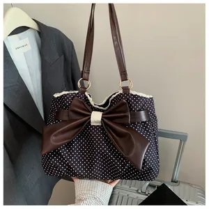 Close-up of retro polka dot tote bag with leather bow and delicate lace trim detail