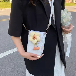 Détail du tissu floral du sac de téléphone blanc avec fleur jaune et breloques orange