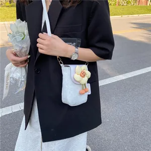 Gros plan du sac pour téléphone en jacquard blanc avec fleur 3D et détails pompons