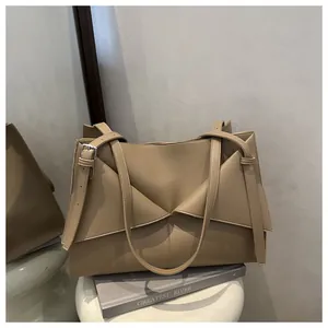 Détail du sac cabas en cuir beige avec pli triangulaire unique et bretelles réglables