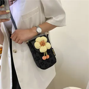 Close-up of a mini crossbody phone bag with a 3D yellow sunflower on jacquard fabric