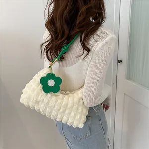 Détail du sac à texture bulle blanc cassé avec une bandoulière en cuir noué vert