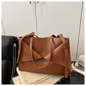 Détail du sac cabas en cuir caramel avec pliage géométrique unique et fine bandoulière
