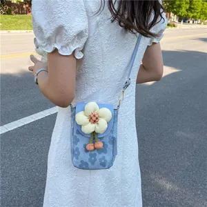 Light blue floral phone bag with 3D white flower decor worn by a woman outdoors