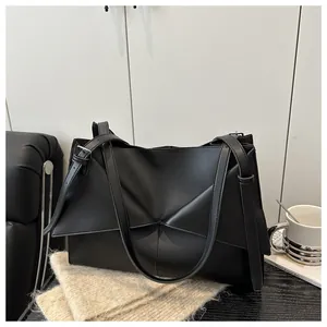Détail du sac cabas en cuir noir montrant le design géométrique et les surpiqûres
