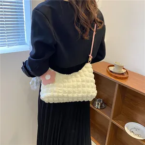 Vue détaillée du sac à bandoulière blanc à bulles avec bandoulière rose et breloque fleur