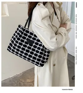 Détail d'un sac cabas à carreaux noir et blanc avec texture tissée et étiquette en cuir