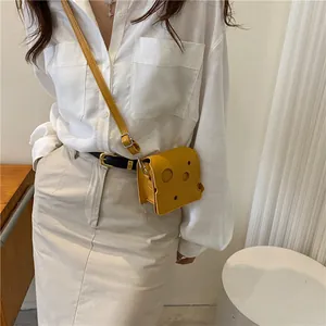 Mini sac bandoulière jaune en forme de fromage avec détails ajourés sur mannequin