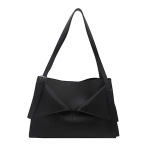 Sac fourre-tout minimaliste en cuir noir avec rabat asymétrique et bandoulière réglable