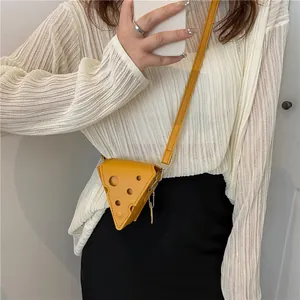 Gros plan du mini sac à bandoulière jaune en forme de fromage avec détails découpés