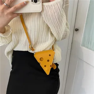 Détail du mini sac bandoulière jaune en forme de fromage avec cercles creux et lanière