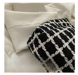 Gros plan sur la texture en tweed à carreaux noir et blanc d'un grand sac cabas