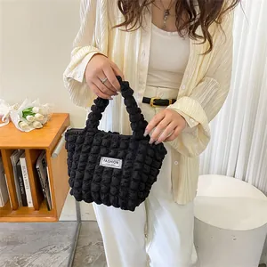 Detail of black bubble texture handbag with fashion instinct label in lifestyle setting