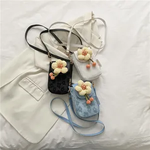 Close-up of mini crossbody bag with embossed floral pattern and 3D flower charms