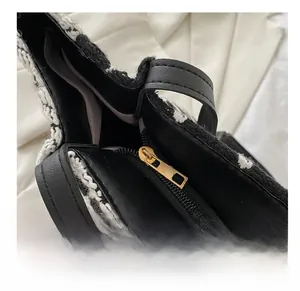 Gros plan de la fermeture éclair dorée et des garnitures en cuir noir sur un sac cabas