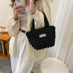 Detail of black puffy bubble texture handbag featuring a white Fashion Instinct label