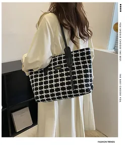 Détail du sac cabas pied-de-poule noir et blanc avec anses en cuir sur mannequin