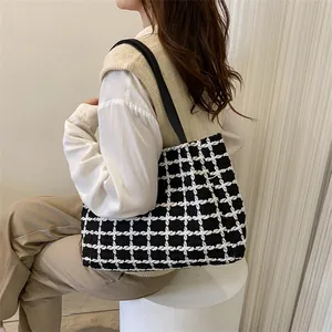 Vue détaillée du sac cabas en tweed à damier noir et blanc avec anses en cuir