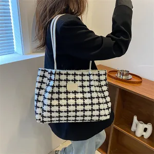 Détail du sac cabas à carreaux noir et blanc avec texture tissée et écusson en cuir