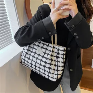 Détail du sac cabas à carreaux avec patch en cuir et bandoulière légère en tissu
