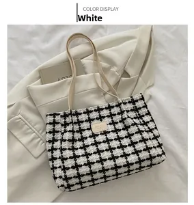 Vue détaillée d'un grand cabas en tweed à carreaux noir et blanc avec poignées en cuir