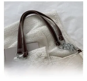 Detail of high-quality leather handle stitching and metal chain on canvas tote bag