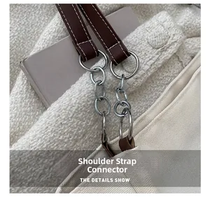 Detail of shoulder strap connection buckle with silver chain and brown leather strap