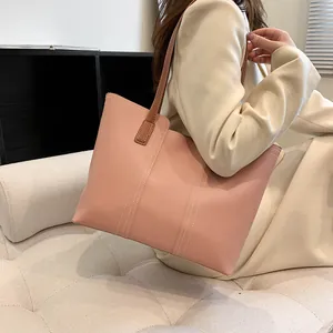Détail du sac cabas rose avec surpiqûres blanches et bandoulières marron chic