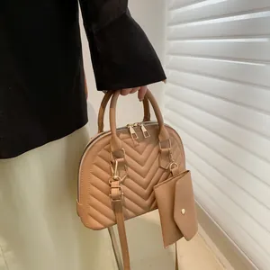 Detail der khakifarbenen Muschel-Tasche mit V-Steppung und passender Mini-Geldbörse
