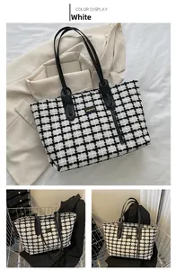 Détail d'un sac cabas à carreaux avec anses en cuir noir et texture de tissu tissé