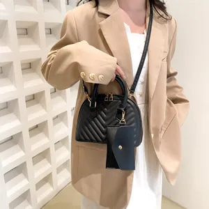 Detail einer schwarzen gesteppten Muscheltasche mit passendem kleinen Münzfach