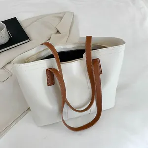 Vue de dessus du grand sac cabas blanc avec anses marron dans un décor minimaliste chic