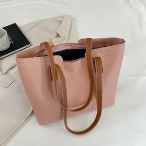 Détail du sac cabas en cuir PU rose poudré avec poignées marron et surpiqûres blanches